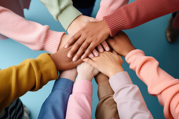 Collaboration and Teamwork: A group of diverse people huddled together, each placing their hand on...