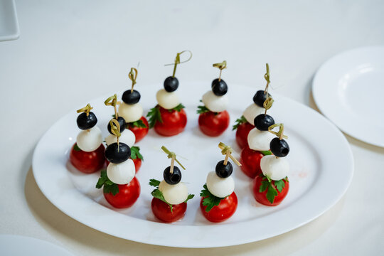 Cherry tomato and cheese canapes, beer appetizer, serving a plate with delicacies, bamboo skewer, takeaway.
