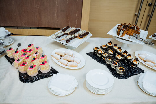 Sweet treat stands on the table, table setting, cake slices, juicy with cottage cheese, catering indoors, sweet table.