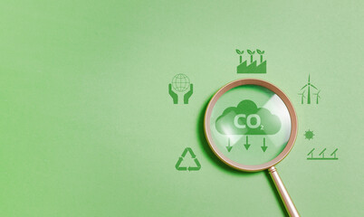 Magnifying glass with reduce CO2 emissions carbon symbol on green background for climate change to limit global warming and sustainable development and green business concept - obrazy, fototapety, plakaty