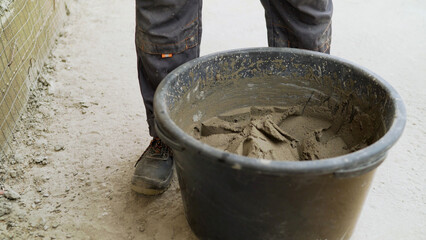 Bucket of cement for construction on a construction site. Mortar with a bucket on the street. Bucket with putty, exterior work. Bucket with construction putty.
