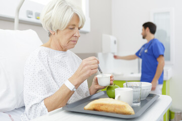 senior hospital patient eating her lunch on a tray