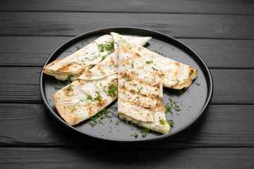 Lavash with grilled suluguni cheese served on a plate with greens