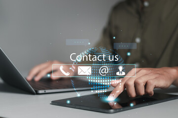 Customer support center contact us. Businessman using computer laptop with contact icons on virtual screen for customer support hotline and people connection.