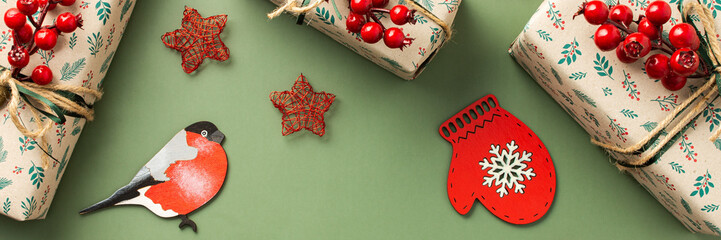 Christmas festive banner, gift boxes with a sprig of rowan and red stars, a bullfinch and a mitten...