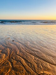 Beautiful sea sand pattern, wet sandy seashore, evening sunlight 