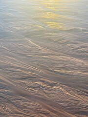 Beautiful sea sand pattern, wet sandy seashore, evening sunlight 
