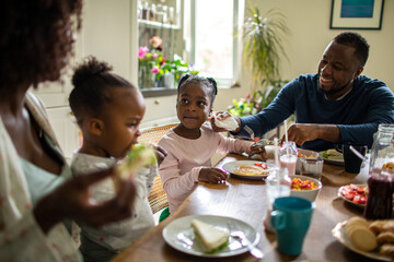 Young family having breakfast together in the kitchen in the morning