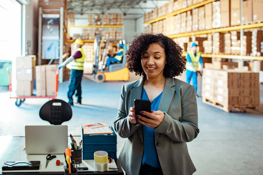 Businesswoman using a smartphone in the warehouse