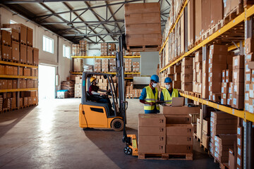 Wide angle view of warehouse workers moving goods and doing inventory