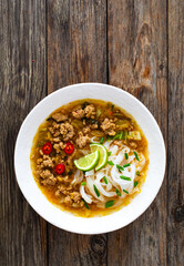 Yunnan rice noodle soup on wooden table
