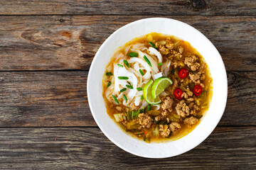 Yunnan rice noodle soup on wooden table
