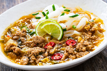 Yunnan rice noodle soup on wooden table
