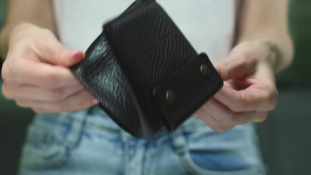 Woman showing empty wallet, no money on blur background