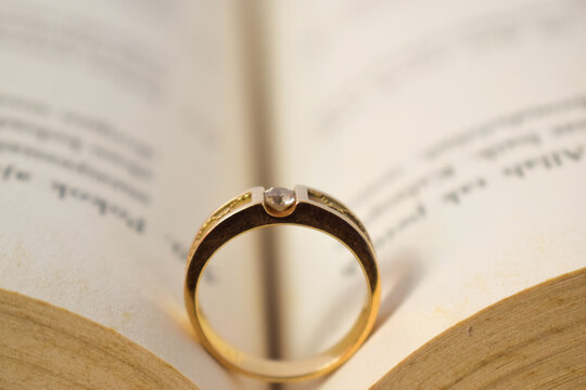 Close up golden ring with diamond between book opened