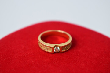 Close Up Golden ring with diamond on red carpet Background