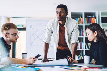 Diverse colleagues working at table in office space