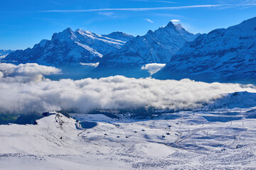 Winter mountain landscape with clouds in the valley in Switzerland.