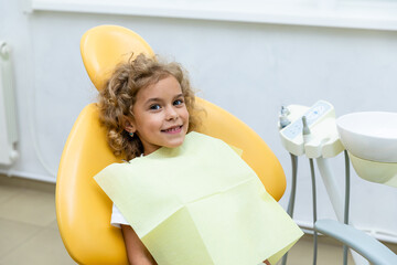 Happy little girl having dentist's appointment in modern clinic. Little patient, adorable little...