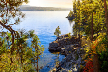 Autumn view of a small sandy beach and rocky cove on Tubbs Hill, a hiking trail loop along Lake...