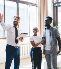 Professional estate agent showing house to African American pleased couple