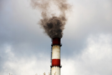 Black smoke from chimney of plant on background of sky © Vera Aksionava