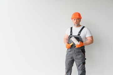 Painter man painting the wall in home, with paint roller and white color paint. Room renovations at house.