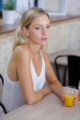 attractive female drinking a glass of fresh orange juice