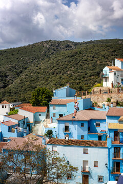 Person doing slide (zip line) in blue painted Smurf village of Juzcar, Pueblos Blancos region, Andalusia, Spain