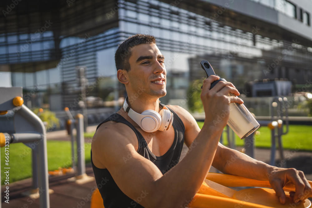 Poster one caucasian man young male athlete take a brake during outdoor training in the park outdoor gym ho