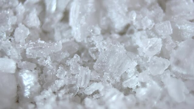 Close-up. Translucent cube-shaped salt crystals rotated on the floor. Natural sea salt. 