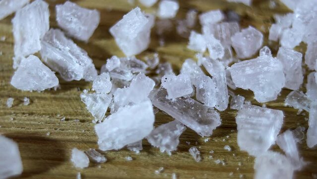 Close-up. Translucent cube-shaped salt crystals rotated on the floor. Natural sea salt. 