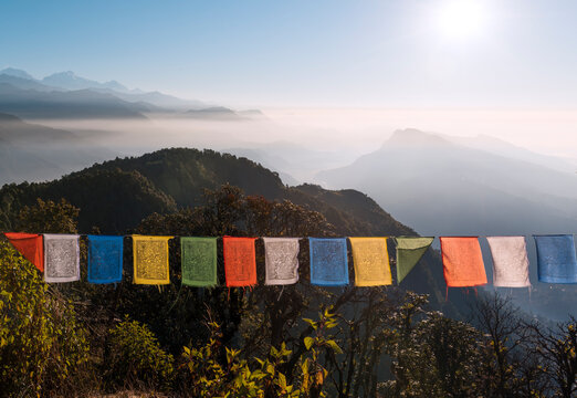 Colorful prayer flags in front of a vast mountain landscape at the foot of the Annapurna Circuit in the Himalayas, Australian Camp, Nepal