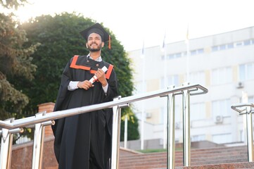education, graduation and people concept - happy Indian Male graduate student.