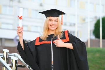 A young female graduate against the background of university.