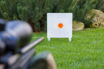 Paintball target on a green grass in a game shooting range. Selective focus