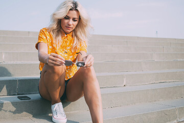 Stylish woman examining shades on steps