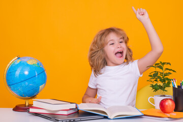 Excited pupil. School kid holding index finger up with great new idea. Child from elementary school with book. Little student, clever nerd pupil ready to study. First time to school. - obrazy, fototapety, plakaty