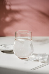 Collagen protein powder and glass of water. Food beauty and health supplement