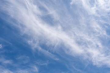 Blue sky with windy clouds. Natural background photo texture taken on sunny day. Cirrus type of clouds