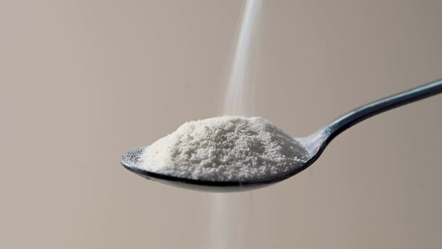 Collagen protein powder pouring in a spoon. Food beauty and health supplement