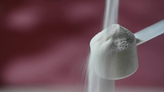 Collagen protein powder pouring in a measuring scoop. Food beauty and health supplement