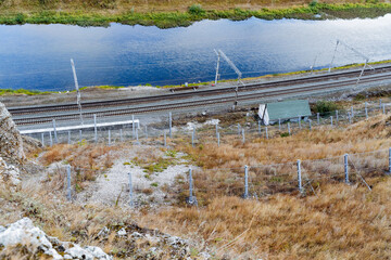 Metal mesh fence on railway tracks, rockfall protection, wire fence, river.