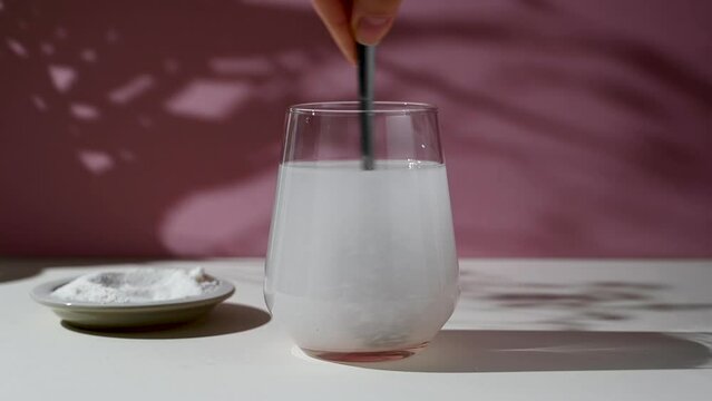 Collagen protein powder mixing in a glass with water. Food beauty and health supplement
