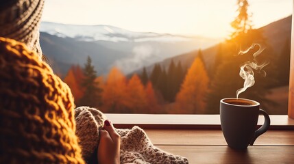 The woman relaxes by the mountain view with a cup of hot drink while wearing woollen socks.