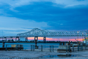 a gorgeous summer landscape along the Mississippi River with the Crescent City Connection bridge...