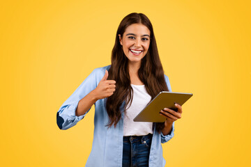 Cheerful caucasian young student woman use tablet, show thumb up gesture