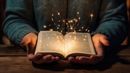A person holding an open book with lights coming out of it - obrazy, fototapety, plakaty