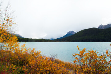 Lake with blue waters in mountains and yellow foliage in autumn.