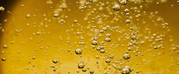 Golden Hyaluron Oil bubbles collagen serum or yellow oil bubbles drop texture background. Liquid...